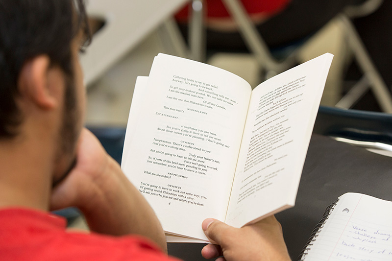 View over shoulder of student reading book